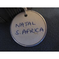 Circular label with metal outline tied to object